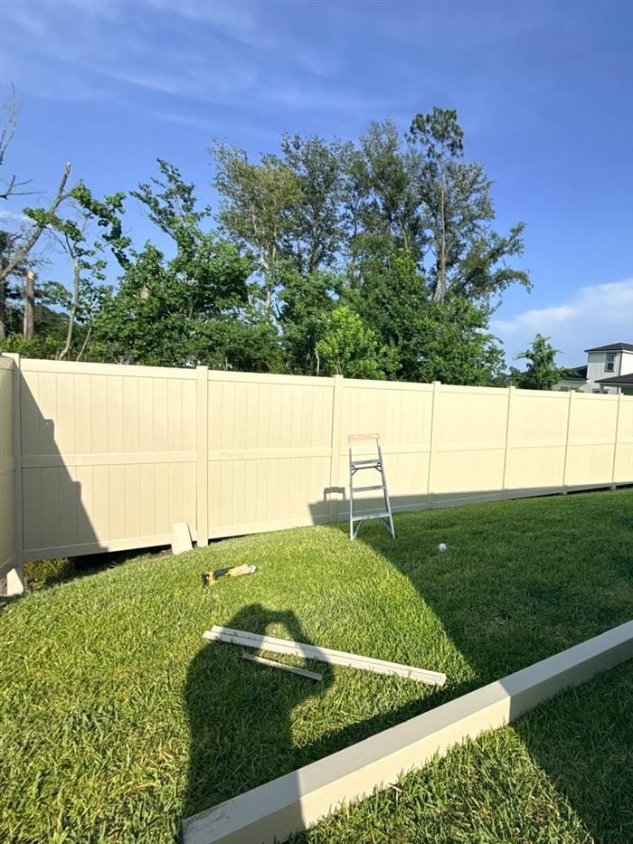 Tan vinyl privacy fence installation in a Jacksonville, FL backyard