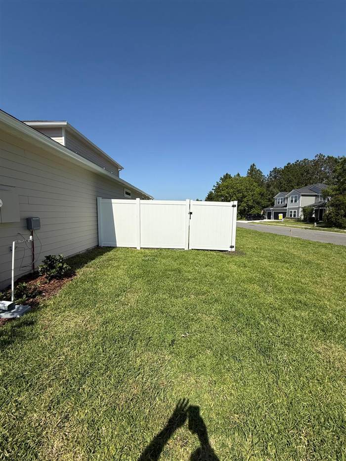 White vinyl fence and gate enclosing a side yard