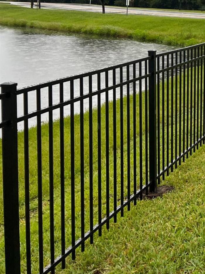 Black aluminum fence along a waterfront property line