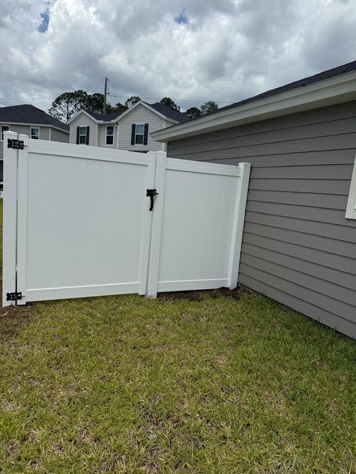 White vinyl single gate next to the house