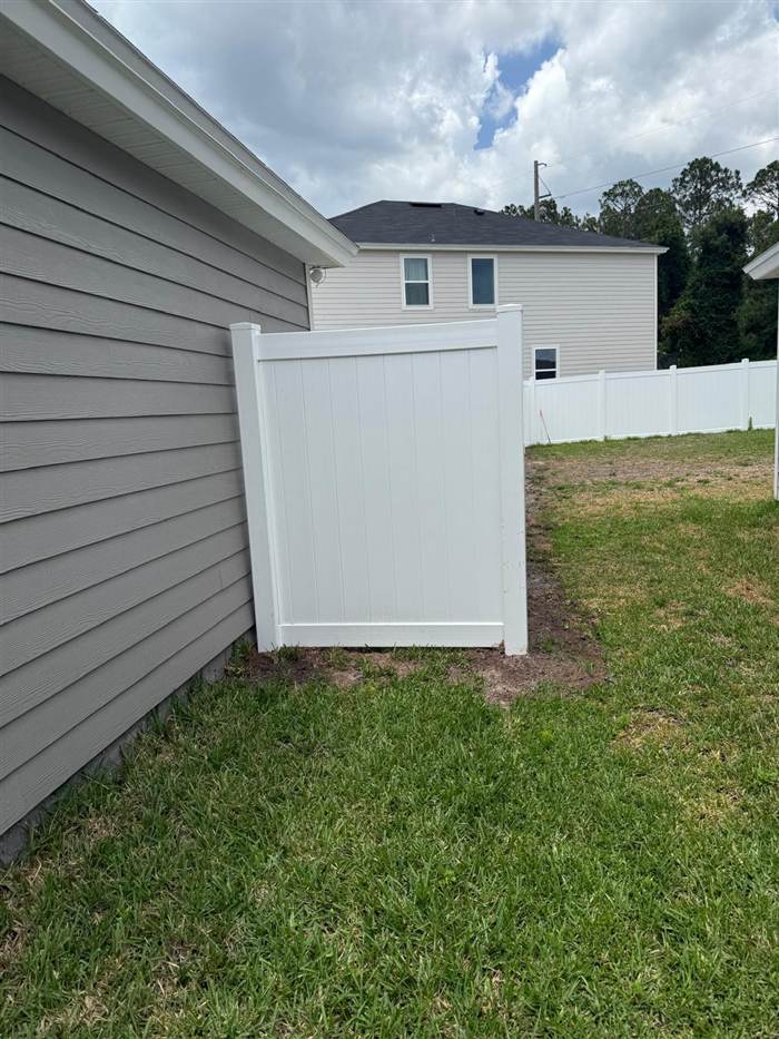 White vinyl fence panel next to the house